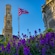 A flag flying in font of an historic watch tower